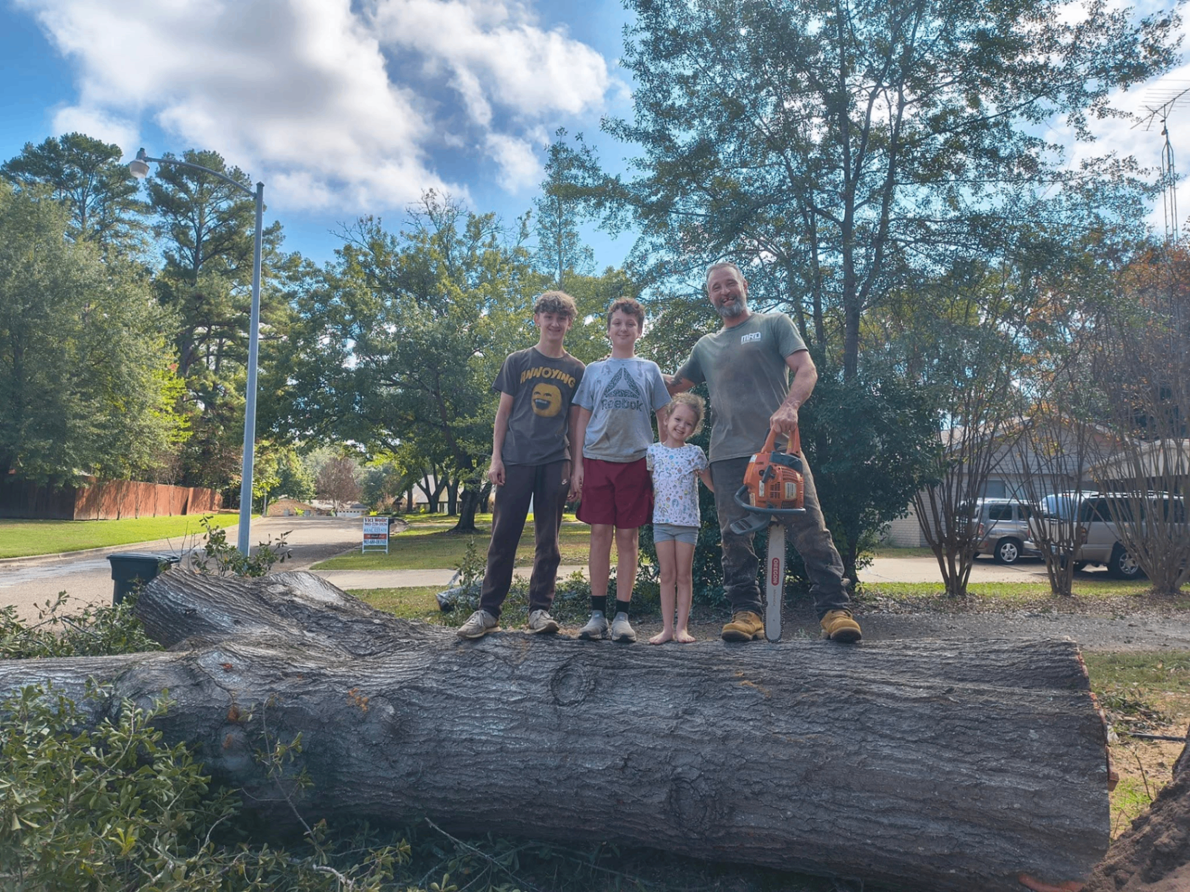 Owner of Ground 2 Crown with his kids standing on a felled oak log